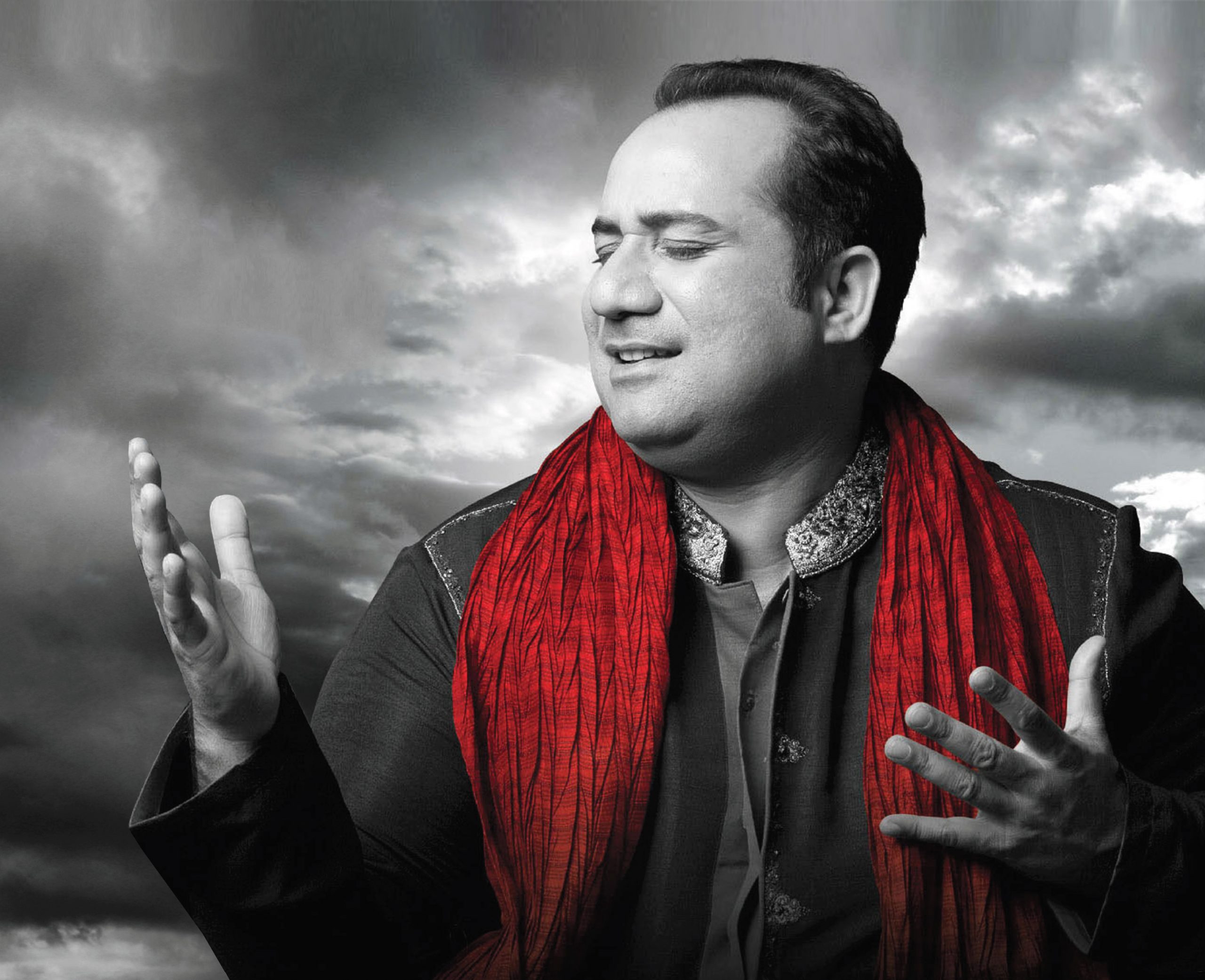 Ustad Rahat Fateh Ali Khanagainst cloudy background in black and white with red scarf coloured