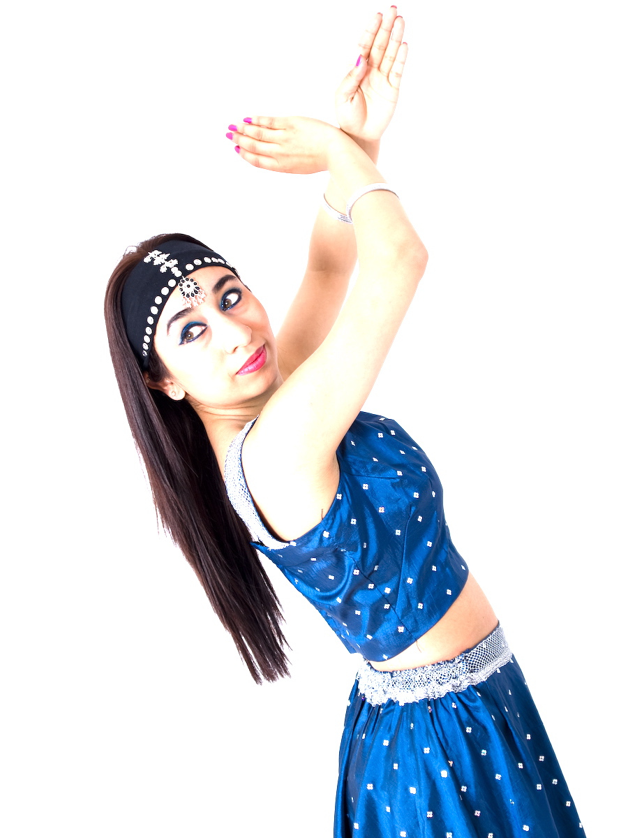 woman facing the back looking forward in a blue two piece top and skirt with her hands clapping above her