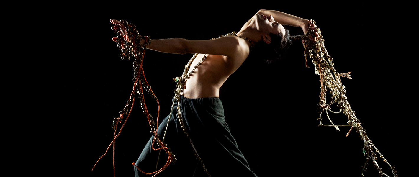 Aakash Odedra Echoes poster with strings of bells in his hand behind and in front of him