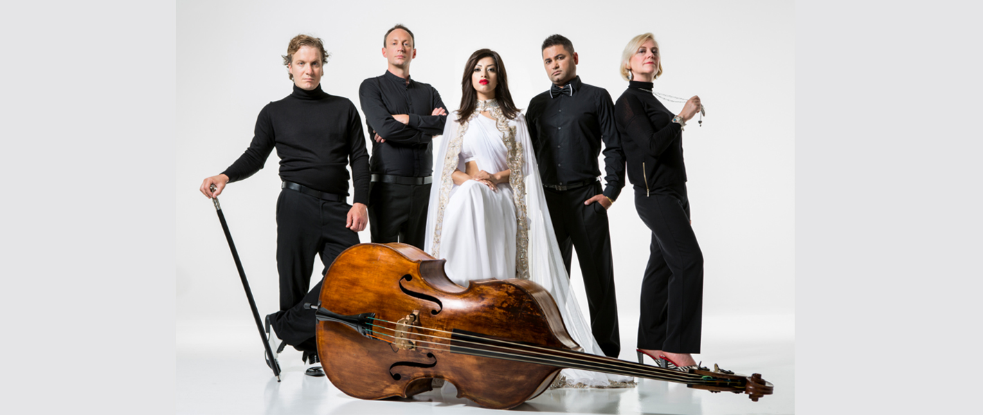 Shapla Salique dressed in white with her band drssed in black and a cello in front of them