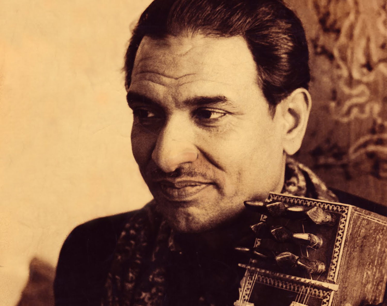 Sepia photo of Ustad Sabri Khan with the head of an instrument