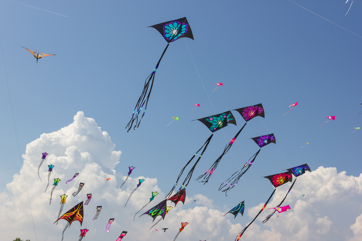 Patang kite flying across a blue clouded sky