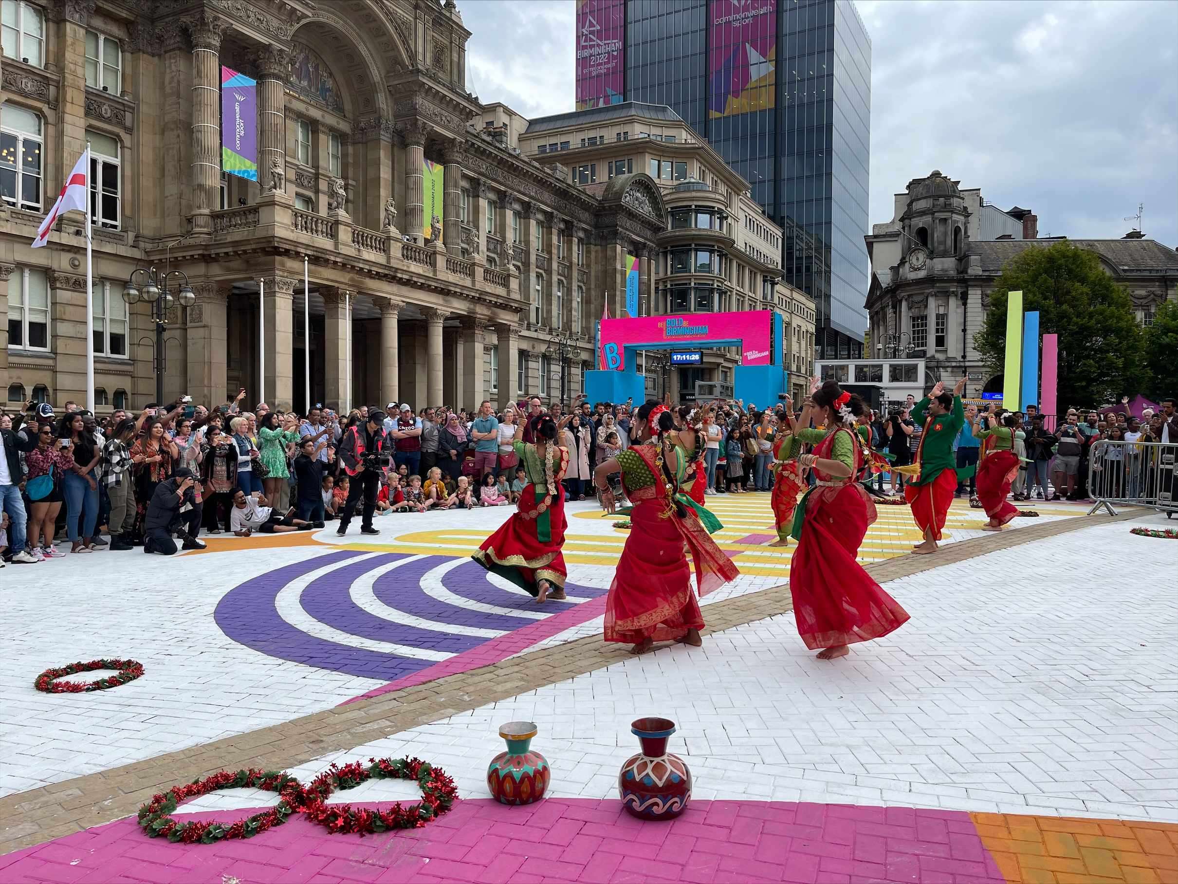 In the town square, audience surround an Indian classical dance group