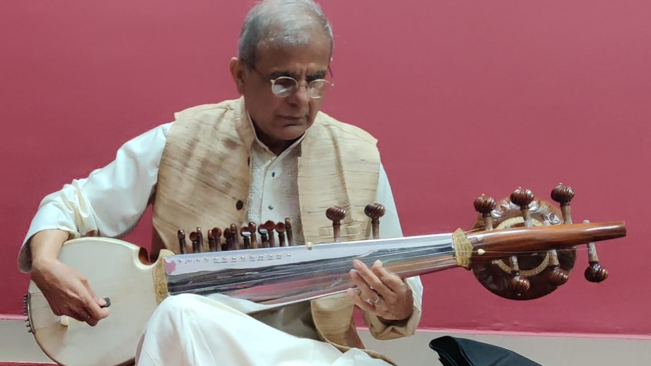 a man playing a stringed instrument sat in his lap
