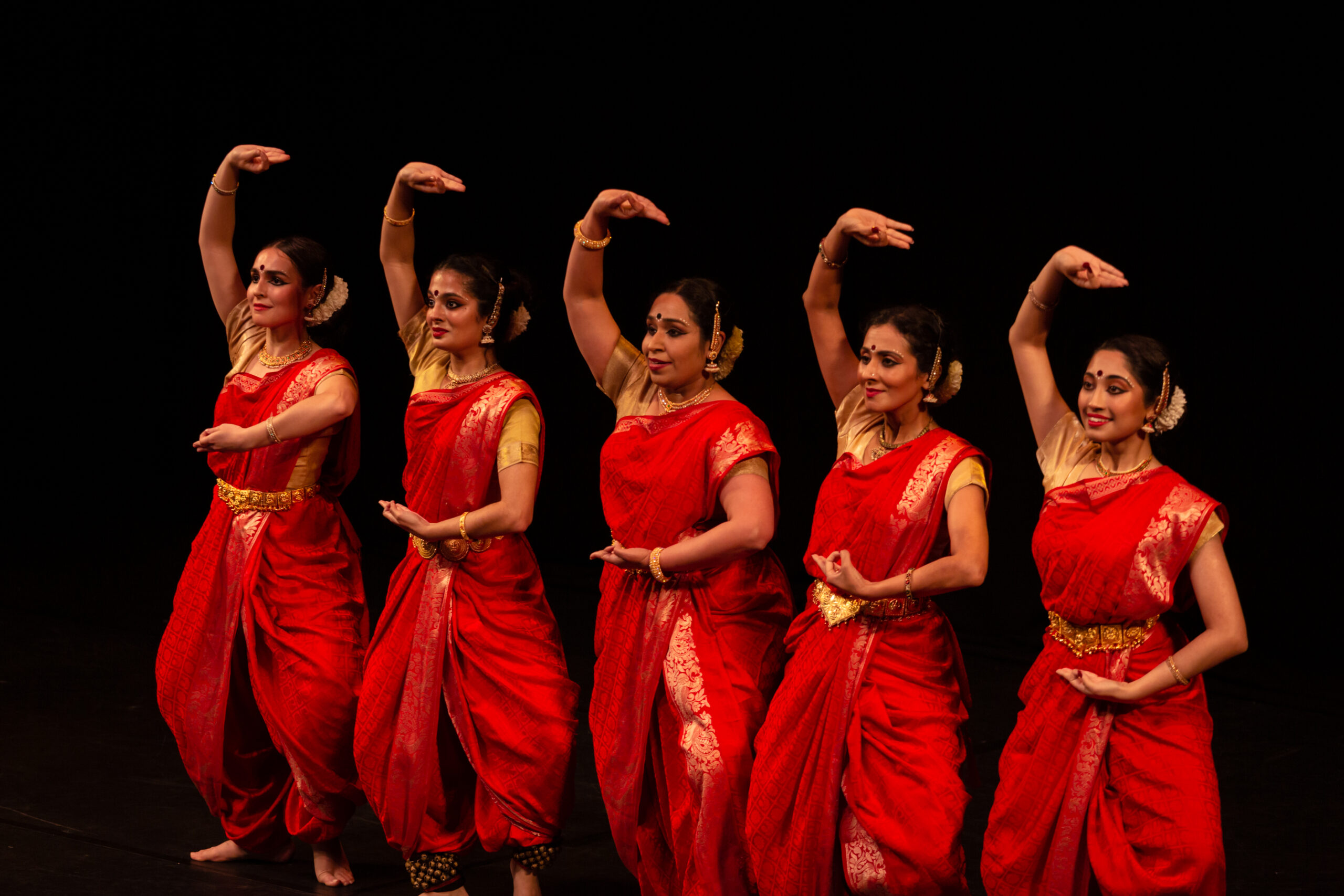 women posing in red saris as part of Asian Spring 2022
