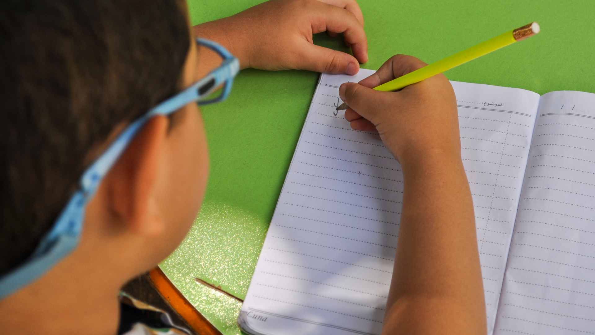 a child writing in a notebook