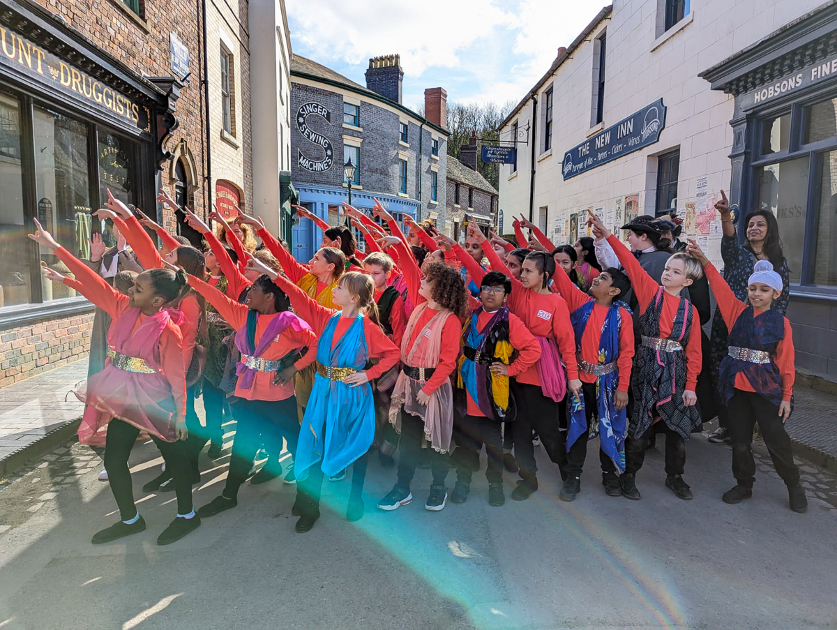 a group of children in a street all posing and pointing up