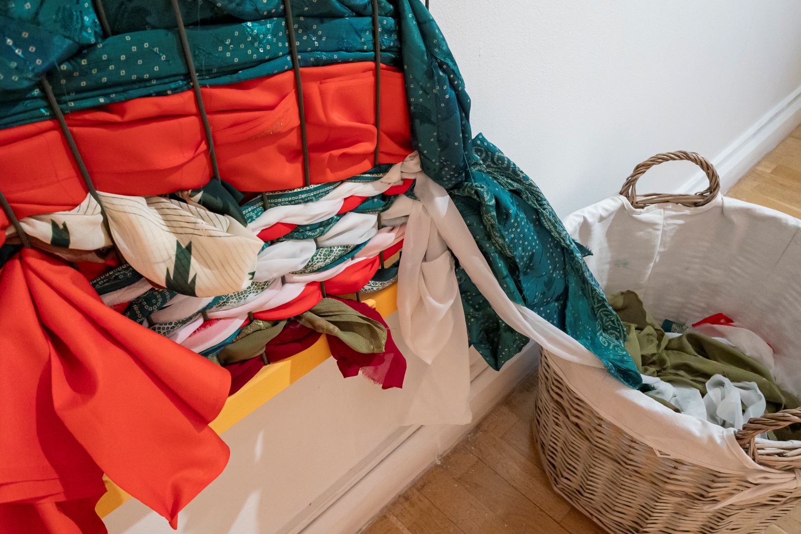 MAC, Community Gallery, Sari Stories woven layered saris next to a basket of fabric