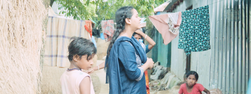 a woman surrounded by children in a village - cropped short