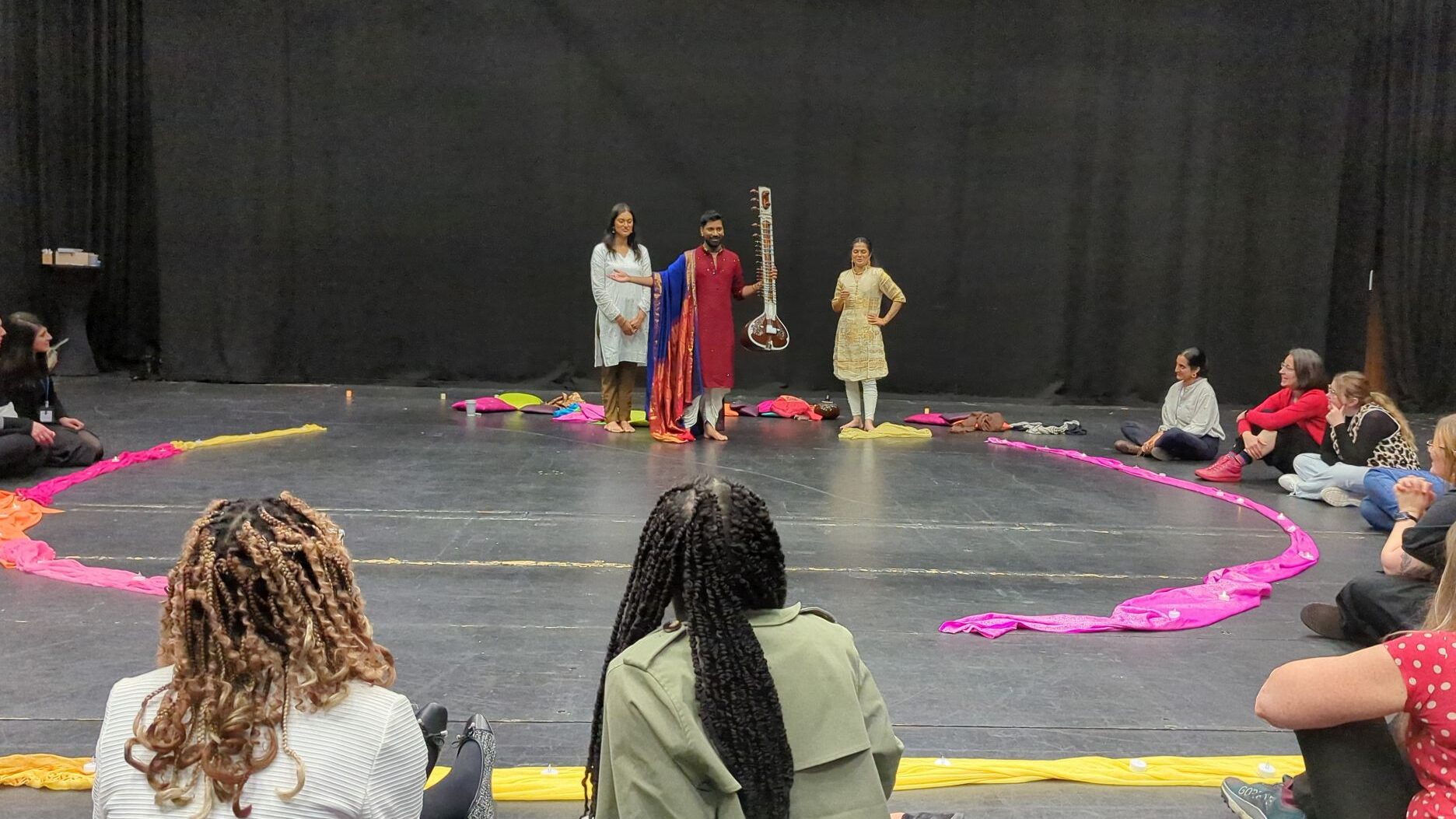 A group watching a musical artist present