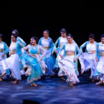 group of nine South Asian dancers in blue
