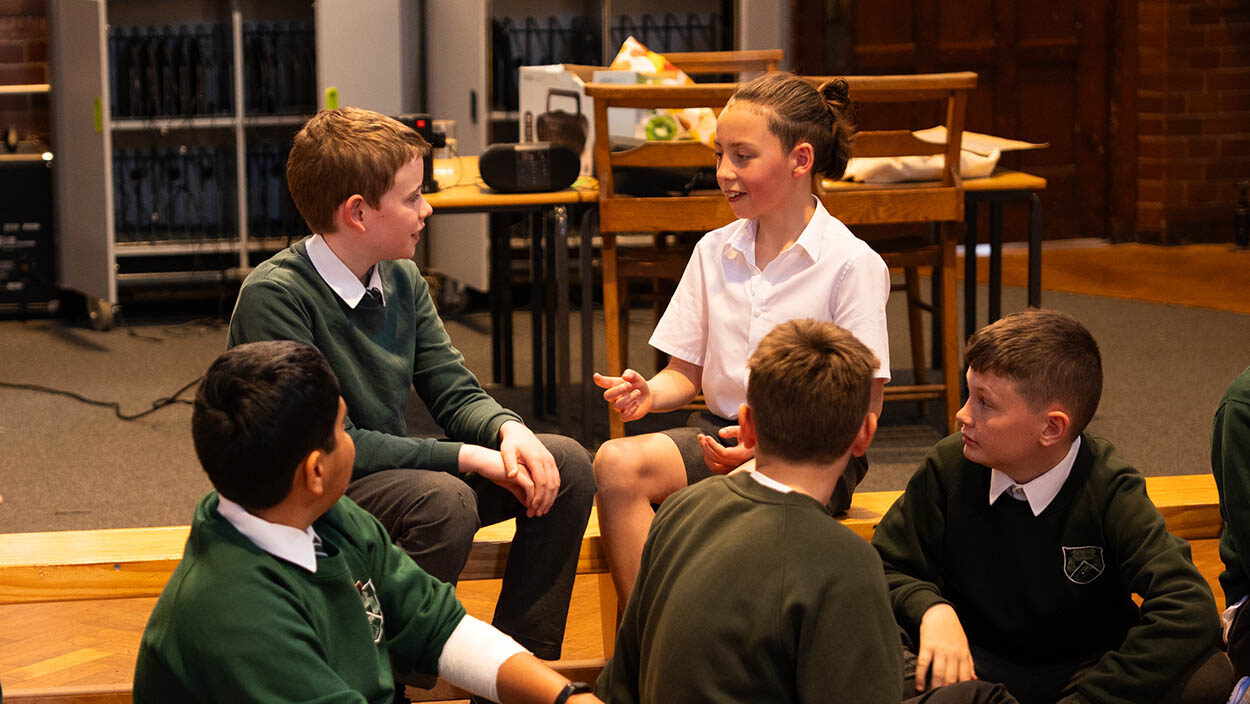 School pupils in a school hall discussing something
