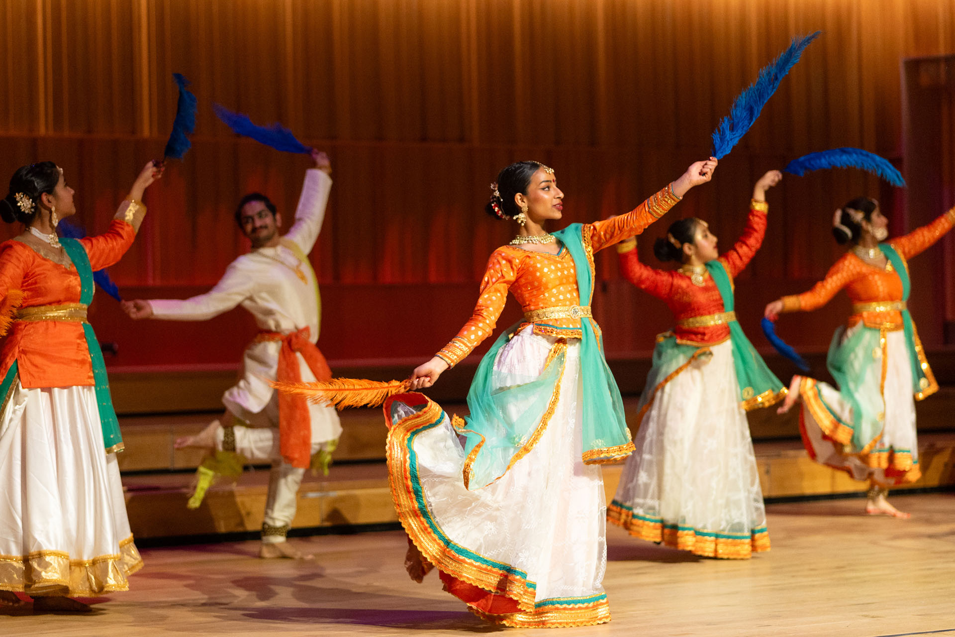 Classical Indian Dance group on stage with feather props